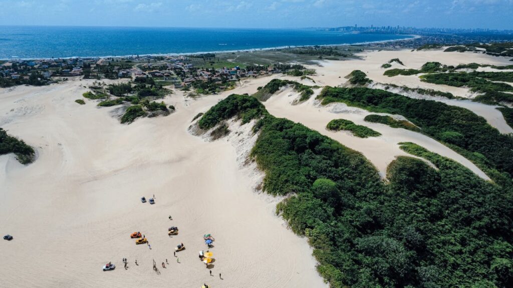 Stunning aerial view of sand dunes and coastline in Natal, Brazil, showcasing natural beauty.